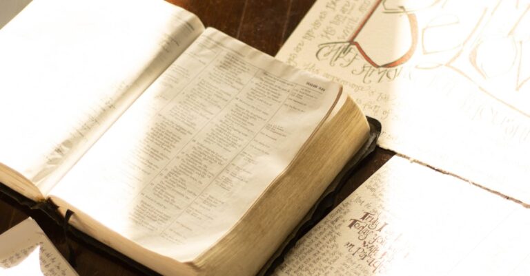 Open Bible with hand-drawn illustrations on a rustic wooden table, bathed in warm light.